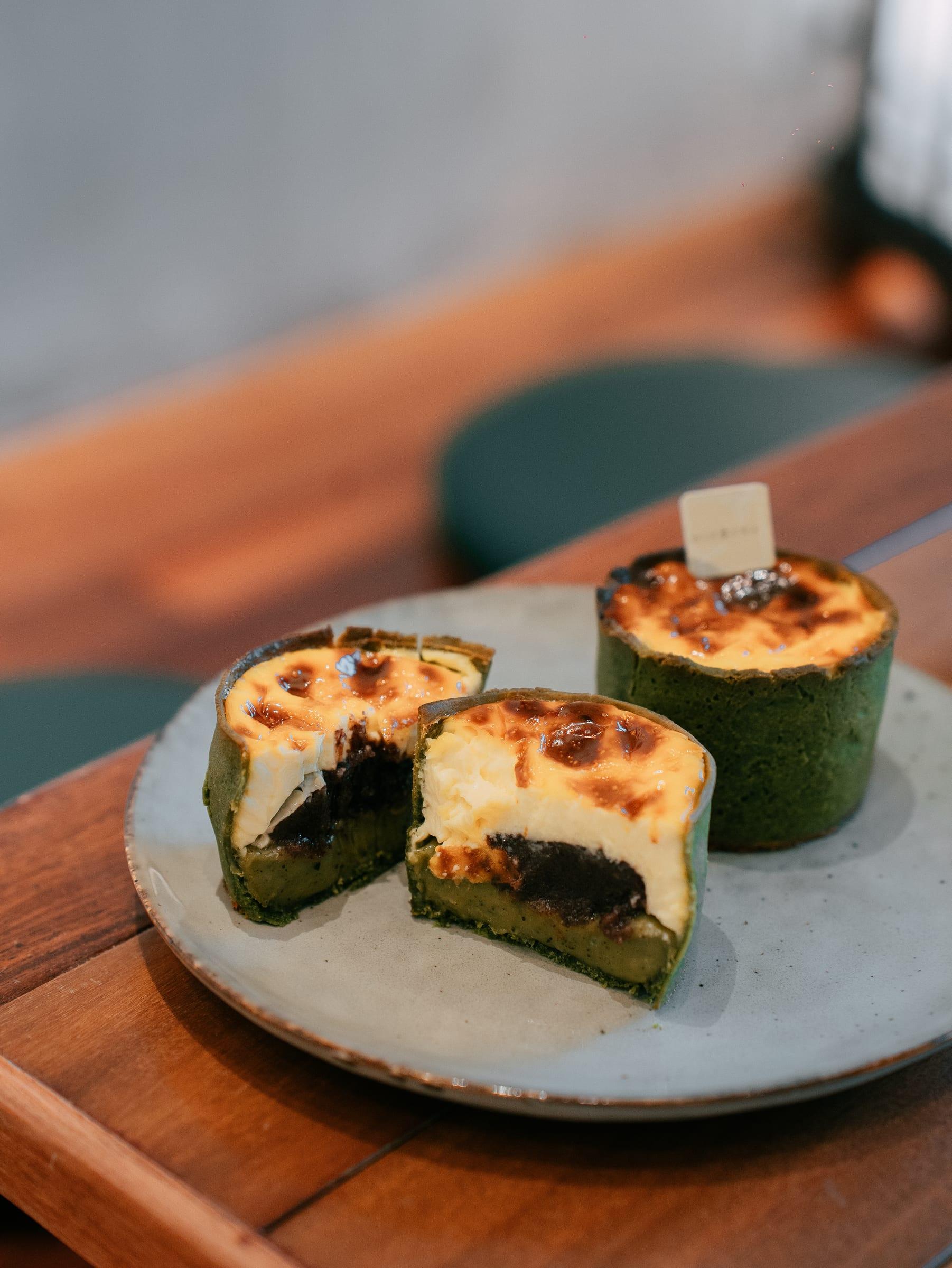 Burnt-top matcha tarts cut open to a red bean centre